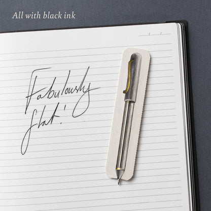 A Fabulously Flat paper pen on a lined notebook page with handwriting in black ink